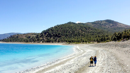 Couple hold hands walking Lake Salda romantic Turkish beach 