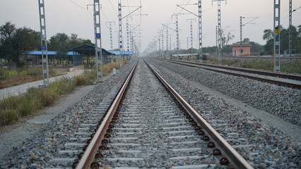 Fototapeta na wymiar Railroad tracks of the Indian Pacific Railway near Jaipur, India. Single track railway line with electricity pole.