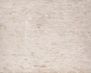 Bricks behind white remainders of old plaster.