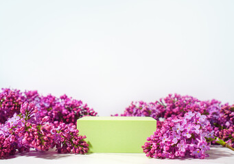 Cosmetics skin care product presentation scene and display made with white green podium and flowers of lilac branch. Studio photography.