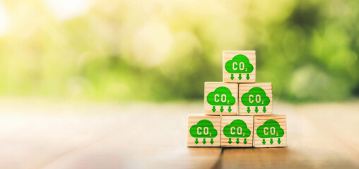 CO2 emission concept. Green industries business concept. Net zero emissions. Renewable energy, sustainable technology, ecology solutions. Hand puts the wooden cubes with CO2 emission reduction icon. - obrazy, fototapety, plakaty