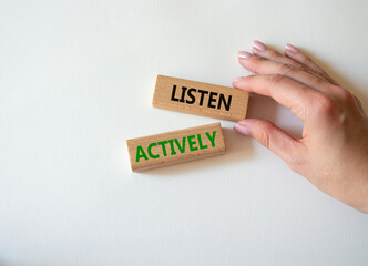 Listen actively symbol. Wooden blocks with words Listen actively. Businessman hand. Beautiful white background. Business and Active listening concept. Copy space.