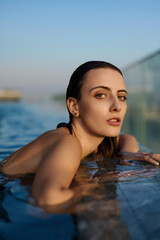 Beautiful girl in the pool in the water.