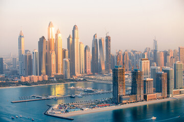 Fototapeta premium Dubai, UAE. Dubai Marina skyscrapers view at golden sunset with beautiful reflection in water. 
