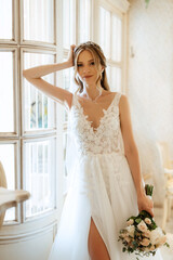 Fototapeta premium portrait of a bride in a white dress in a bright cafe