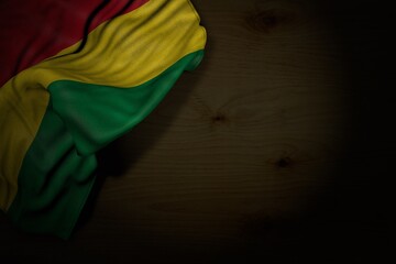 pretty celebration flag 3d illustration. - dark image of Bolivia flag with large folds on dark wood with free space for your content