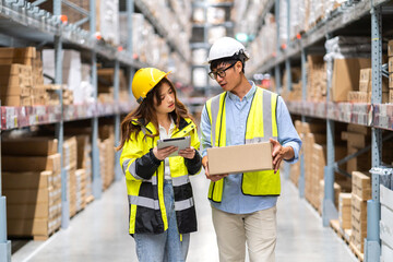 Asian two engineer team shipping order detail on tablet check goods and supplies on shelves with goods background inventory in factory warehouse.logistic industry and business export