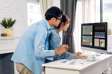 Young smiling asian couple relax using laptop work, analyzing data management system and make report with KPI, strategy, finance, sales, marketing, money, business growth, financial investment graph