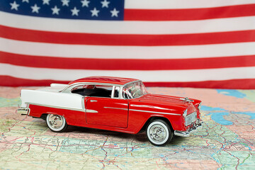 Red and white 1955 Chevy car on a road map with an American flag background