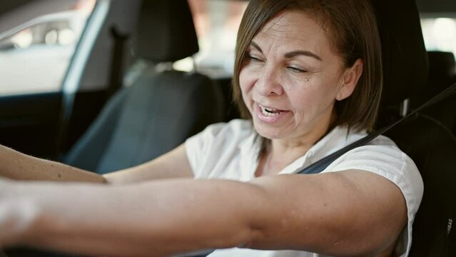 Middle age hispanic woman stressed driving car at street