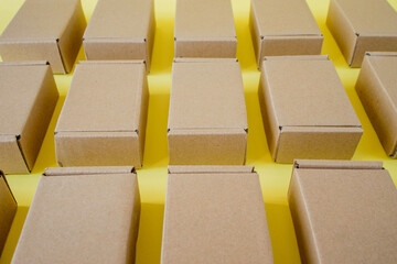 Many cardboard kraft boxes on a yellow background. Packing the parcel.