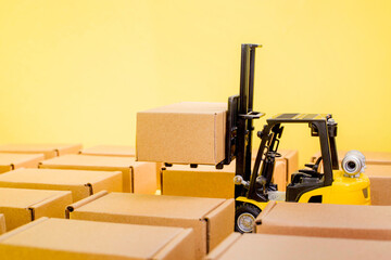 Warehouse with cardboard kraft boxes and a forklift truck. Cargo sorting and product delivery concept