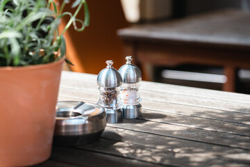 Pepper shaker and salt shaker on the table of a city restaurant.