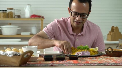 Indian men using hand to be picking up Indian food placed on the table, which is the culture of eating Indian food.	