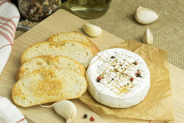 Camembert cheese with spices and sauce. Close-up of camembert and croutons