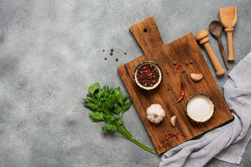 Culinary background. Wooden cutting boards, spices and parsley, gray grunge background. Top view, flat lay, copy space.