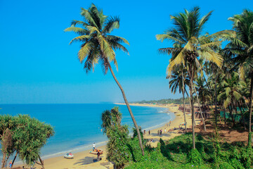 Sunny Beach with Tourists in the Goa state, India - obrazy, fototapety, plakaty