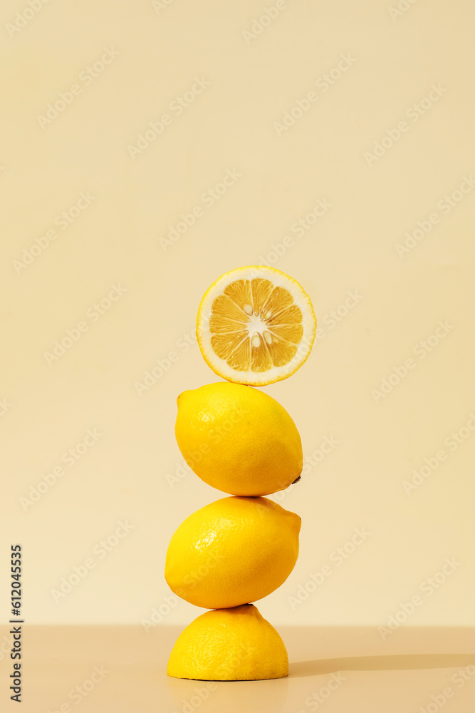 Wall mural a pyramid of juicy yellow lemons on a beige background. creative concept of fruits, citrus fruits.