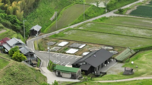 Traditional Japanese houses by historic thatched roof houses and green fields