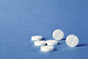 White round medical pills on a blue background