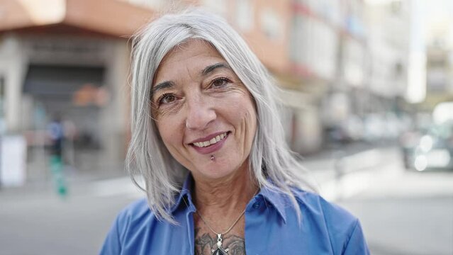 Middle age grey-haired woman smiling confident standing at street