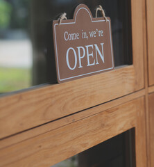 Welcome. Open. barista, waitress woman turning open sign board on glass door in modern cafe coffee shop ready to service, cafe restaurant, retail store, small business owner, food and drink concept