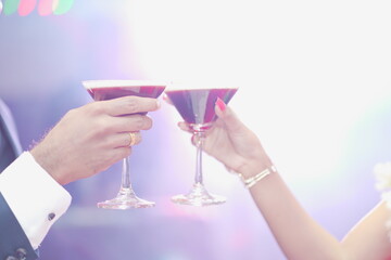 two hands holding glasses of champagne