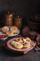Homemade pancakes with raspberries on vintage plates on a dark background. Close up - 612053991