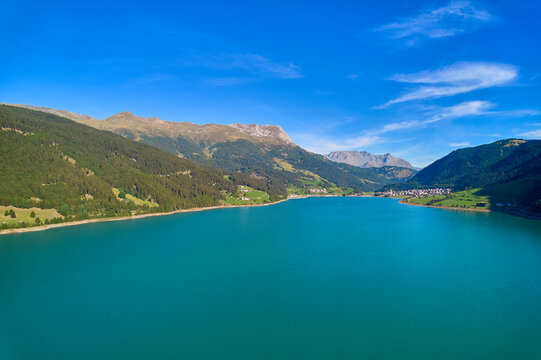 Aerial view of lake (Reschensee). Large reservoir surrounded by mountains at sunny noon. Recreation area for tourists and sportsmen. Italy, Vinschgau, Reschen. © Jan