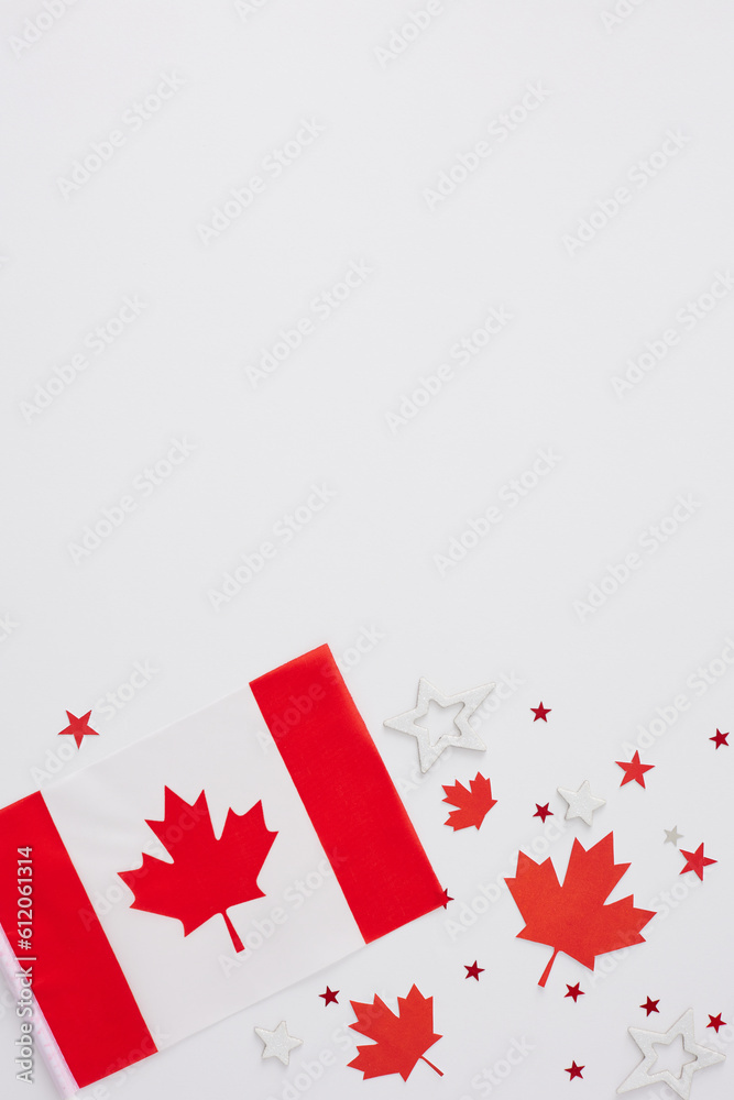 Wall mural Canada Day celebration concept. Top view vertical flat lay of national flag, maple leaves, red, white stars on white background with blank space for greeting or advert