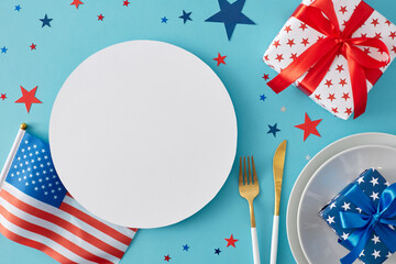 Obraz premium Patriotic table design for America's Independence Day festivities. Top view flat lay of national flag, plates, cutlery, gift boxes confetti on pastel blue background with circle for text or promo