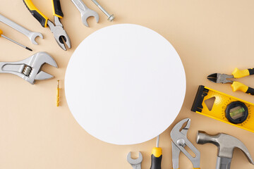 Concept of hand tools for repair. Top view flat lay of manual tools on pastel beige background with blank circle for text or advert