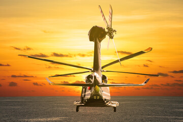 Helicopter flying into the sky with sunset or sunrise. The flight on the sky and travel to other...