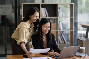 Two asian businesswoman sitting and consulting business inside modern office