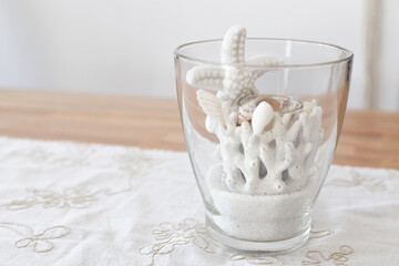 Starfish and corals in the glass on the table

