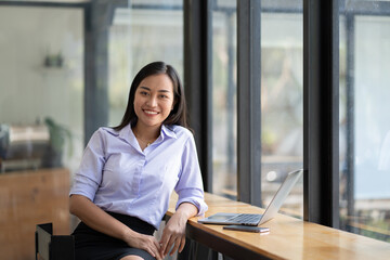 Asian woman working with laptop in her office. business financial concept.