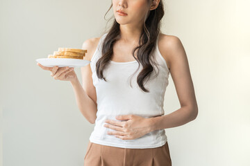 Gluten allergy, asian young woman hand holding, refusing to eat, looking at bread slice on plate in...