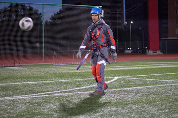 A worker plays soccer. Rope access and soccer.Mountaineers play soccer at night in the stadium.