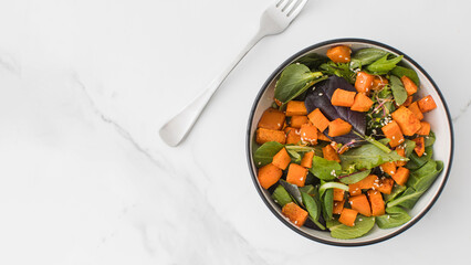  Green salad with sweet potatoes and sesame seeds. Vegan dish. Healthy eating. Copy space