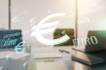 Double exposure of creative EURO symbols hologram and modern desktop with laptop on background. Banking and investing concept