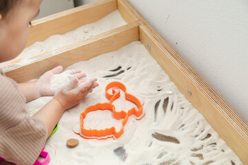 Closeup of toddler playing kinetic sand