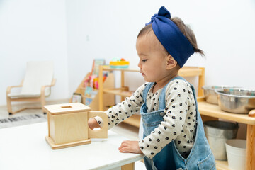Toddler playing with montessori square shape box