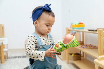 Toddler girl playing with plastic doll