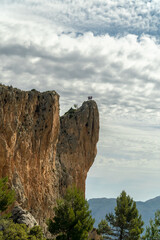  Landscape with three mountaineers posing on the mountain peak.