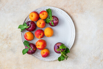 Plate with fresh plums and apricots