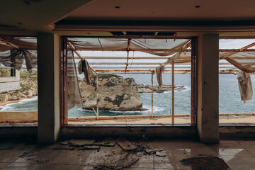 Obraz premium Beirut, Lebanon — 24.04.2023: Abandoned restaurant on the waterfront of Beirut overlooking the famous Pigeon Rocks