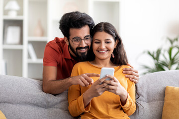 Shopping App. Happy Indian Couple Using Smartphone At Home Together