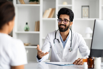 Middle eastern man doctor consulting woman patient at clinic