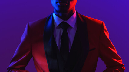 Gentleman fashion. Dandy style. Party look. Neon light unrecognizable confident man in red elegant...