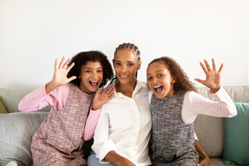 Funny African American Daughters And Mom Waving Hands At Home